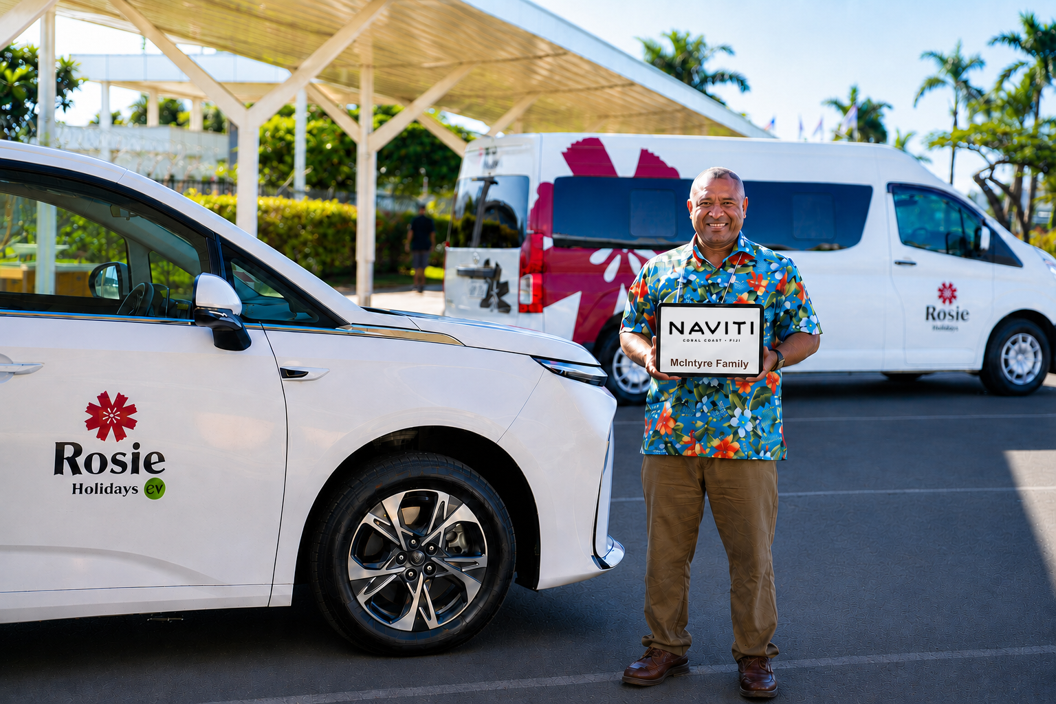 Rosie Holidays driver with The Naviti Resort meet & greet sign beside EV