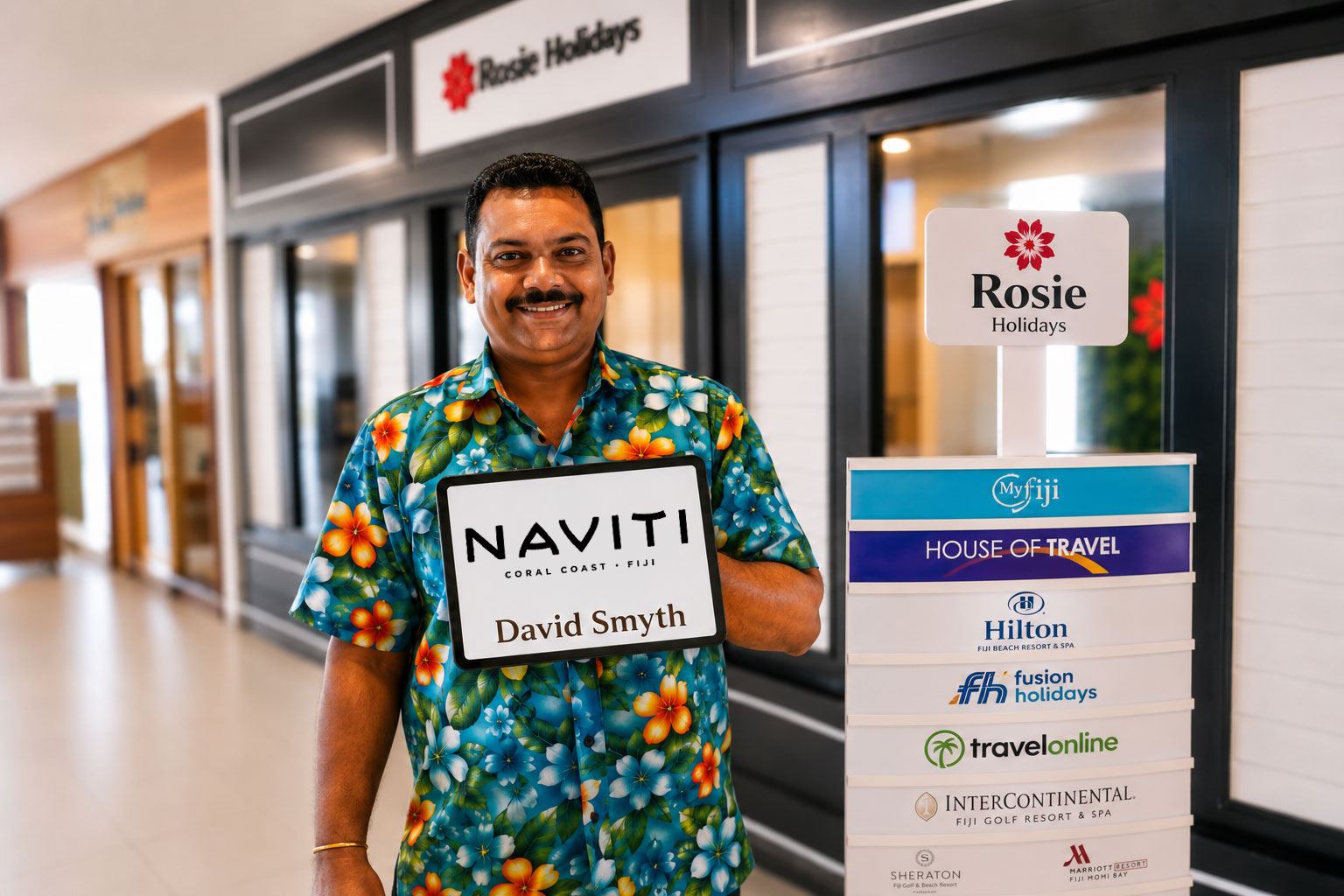 Rosie Holidays driver concierge with Naviti welcome sign at Nadi Airport